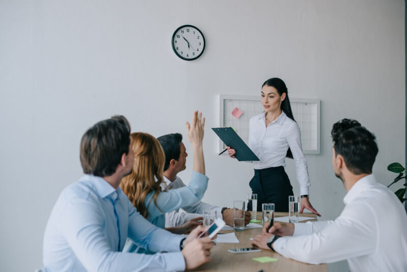 A woman giving a training presentation to her colleagues in a conference room.