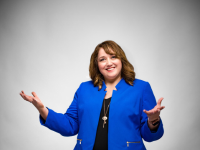 Connie Schroeder professional headshot with arms extended in welcome pose.